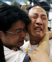 O técnico, Sun Haiping (à dir.) chora após Liu Xiang abandonar a prova dos 110 metros com barreiras.    Foto: Reuters