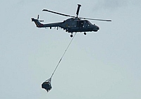 Um helicóptero das Forças Armadas Brasileiras carrega um dos destroços encontrados no mar.Foto: Reuters