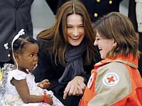A primeira-dama da França, Carla Bruni Sarkozy, foi ao aeroporto recepcionar as 33 crianças haitianas adotadas por famílias francesas que chegaram nesta sexta-feira a Paris.  Foto: Reuters