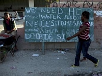 Cartazes espalhados pelas ruas de Porto Príncipe pedem ajuda internacional para o Haiti.  Foto: Reuters