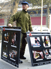 胡佳在北京街头展示河南爱滋病患者的照片(2003/03/09)(路透社)
