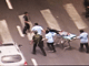 2009年7月13日，一名公安因调解维族人打架而遇到袭击受伤，被送上救护车，图片右上角看到有持枪武警在旁戒备。（郑汉良摄自香港NOW宽频电视台）