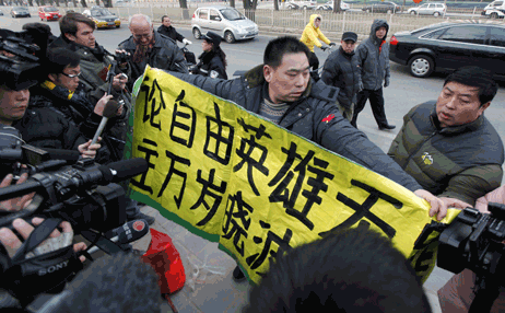 北京第二法院门前一名便衣警察试图扯掉支持刘晓波横幅　2009年12月23日照片：路透社