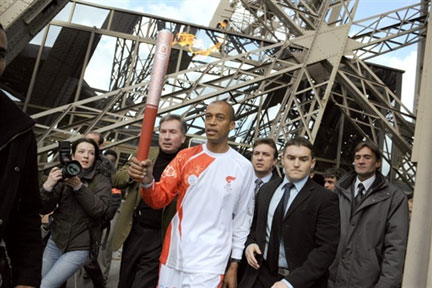 Stéphane Diagana, world 400 metres hurdles champion carries the Olympic torch from the Eiffel Tower(Photo : AFP)