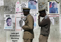 A police patrol passes in front of presidential election posters in Zimbabwe.Photo: Reuters