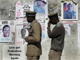 A police patrol passes in front of presidential election posters in Zimbabwe, April 9, 2008.Reuters