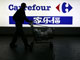 A customer in front of a Carrefour sign in Shanghai(Photo: Reuters)