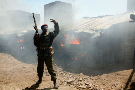 A riot policeman in front of houses set on fire during ethnic violence, Nairobi 2 January 2008(Photo: Reuters)