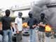 Hezbollah supporters pose as tyres burn on a main road to Beirut airport 7 May 2008. (Photo: Reuters)