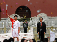 Chinese President Hu Jintao, gives the flame to the first athlete, Liu Xiang.(Photo : Reuters)