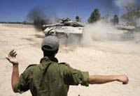 An Israeli soldier directs a tank outside Gaza(Credit: Reuters)