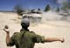 An Israeli soldier directs a tank outside Gaza(Credit: Reuters)