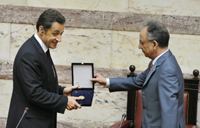 Nicolas Sarkozy (L) receives a gift from the Speaker of the Greek Parliament Dimitri Sioufas(Photo: Retuers)