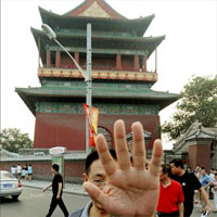 A Chinese police officer attempts to block the camera at the Drum tower.(Photo: AFP)