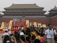 Torchbearer Yang Liwei (L), China's first astronaut, carries the Olympic flame outside the Forbidden city. (Photo: Reuters)