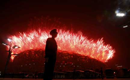 A paramilitary policeman keeps watch as fireworks illuminate the sky(Photo: Reuters)