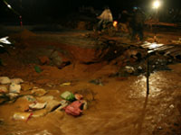 Residents cross a destroyed bridge caused by a landslide in Vietnam's northern province of Yen Bai August 10, 2008.(Photo: Reuters)