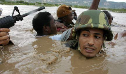 UN soldiers help Haitians cross a flooded river(Photo: Reuters)