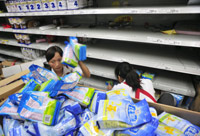 Shopworkers remove contaminated milk powder from the shelves(Photo: Reuters)
