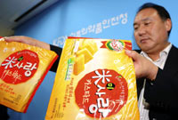 A Korean official shows snacks in which melamine was found(Photo: Reuters)