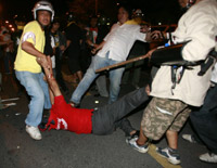 A government supporter is kicked by an anti-government demonstrator (Photo: Reuters)