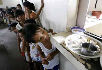 Children in a Philippines slum queue for free meals(Photo: Reuters)