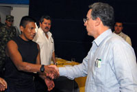  Alvaro Uribe (R) shakes the hand of ex-rebel "Isaza" (Photo: Reuters)