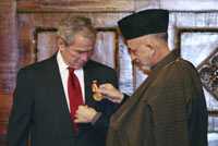 Afghan President Hamid Karzai gives a medal to George Bush in Kabul this week(Photo: Reuters)