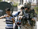 A boy pretending to hold a weapon alongside a British soldier during a patrol in Basra.(Photo: Reuters)
