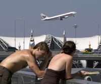 Stranded British tourists Paul Ayling and Selena Woods at Bangkok's Suvarnabhumi airport as a plane takes off(Photo: Reuters)