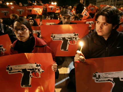 People holding posters featuring pistols gather in front Greece's parliament during a peaceful protest in Athens on Tuesday
(Photo: Reuters)