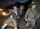 An Israeli police officer detains a Jewish settler (Credit: Reuters)