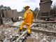 A firefighter inspects the remains of a house destroyed in Wandong, 55 kilometres north of Melbourne.(Photo: Reuters)
