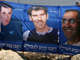 Israeli protesters stand behind a poster depicting abducted Israeli soldiers Ehud Goldwasser (R), Eldad Regev (C) and Gilad Shalit (L) during a demonstration outside the Prime Minister's office in Jerusalem lasst year(Photo: Reuters)