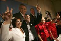 Mauricio Funes (c) claims victory at a news conference, with his wife, Vanda Pignato (l) and running mate Sanchez Ceren (r)(Photo: Reuters)