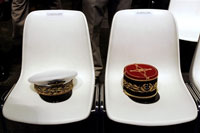 The kepis of French Air Force chief of staff Stephane Abrial, left, and French Army chief of staff Bruno Cuche, right, before a speech in which President Sarkozy that France woulsl soon rejoin Nato's military command that it left in 1966. (Photo: AFP)