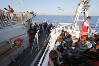 The Italian navy seizing a boat of illegal immigrants 3 August 2008.(Photo: AFP)