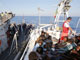 The Italian navy seizing a boat of illegal immigrants 3 August 2008.(Photo: AFP)