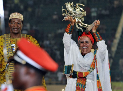 Sélomé Gerima, sister of Ethiopian Haile Gerima, who directed the film "Téza" holds the Golden Stallion of Yennenga - Left is Burkina Faso president Blaise Compaoré.(Photo : AFP)