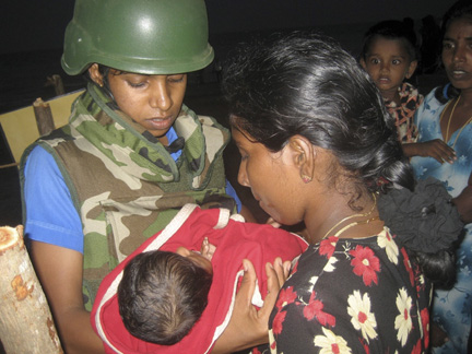 A Sri Lankan Navy medical personnel carries an injured Tamil baby(Photo: Reuters)