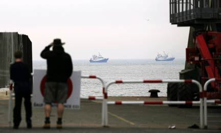 Stranded tourists look at French fishing boats that form part of a blockade at the Port of Calais(Photo: Reuters)
