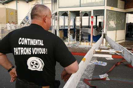 An employee of Continental tyre factory looks at the guard post which was attacked by workers in Clairoix. his T-shirt reads "Continental bosses - thugs!"(Photo: Reuters)