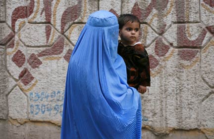 A woman wearing a burqa carries her child through the streets of Peshawar, in Pakistan's North West Frontier Province(Photo: Reuters)