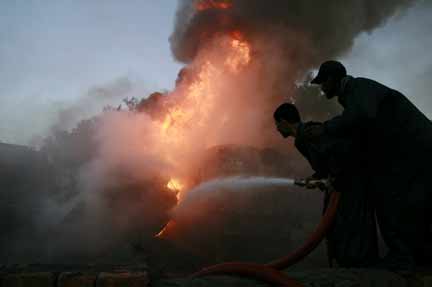 Men try to extinguish a ravaging fire after fuel trucks were set aflame in the northwestern city of Peshawar(Photo: Reuters)