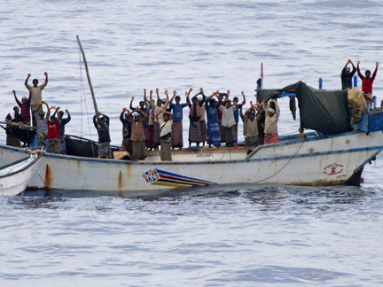 Hostages and pirates stand with their hands up before the intervention of Nato soldiers off Somalia's coast(Photo: Reuters)