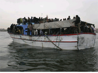 A boat overflowing with migrants, which survived a violent storm, arrives in the port of Tripoli 29 March 2009.(Photo: Reuters)