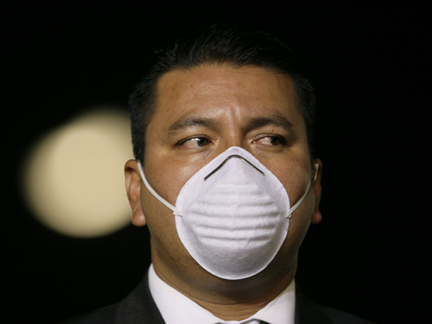 A Mexican presidential security officer wears a mask to guard against H1N1 infection at an event in Mexico City on 1 May 2009(Photo: Reuters)