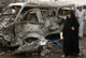 A woman walks beside a damaged vehicle at the site of the bomb attack in Baghdad's Shula district(Photo: Reuters)