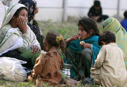 An internally displaced woman, fleeing military operations in Buner, sits with her children at a UNHCR camp(Photo: Reuters)