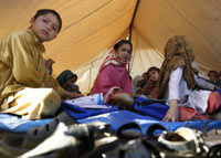 Internally displaced children in Swabi district, hold classes inside a tent at an UNHCR camp, 11 May 2009. Photo: REUTERS Mian Khursheed 